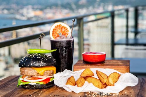 a hamburger and chips on a table with a drink at Sheraton Batumi Hotel in Batumi