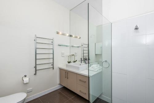 La salle de bains blanche est pourvue d'un lavabo et de toilettes. dans l'établissement Serpentine Park on View, à Bendigo
