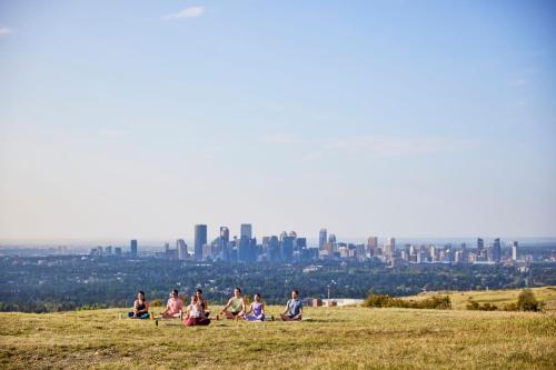 a group of people sitting on a hill with a city in the background at Courtyard by Marriott Calgary Airport in Calgary
