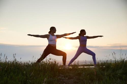 two women doing yoga on a hill at sunset at Courtyard by Marriott Calgary Airport in Calgary