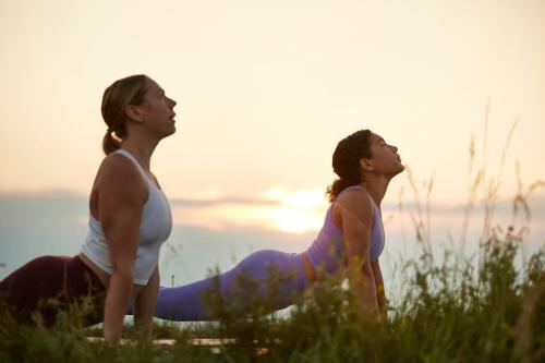 two women sitting in a field doing yoga at Courtyard by Marriott Calgary Airport in Calgary
