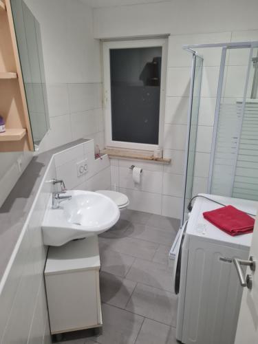 bagno con lavandino, servizi igienici e finestra di Admira DGL, Monteurwohnung a Geeste