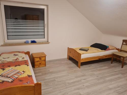 a small room with two beds and a window at Admira DGL, Monteurwohnung in Geeste