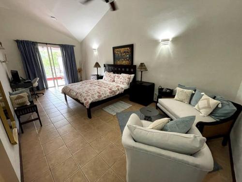 uma sala de estar com um sofá e uma cama em Lovely 2 Bedroom Apartment with Pool Front em Los Conucos