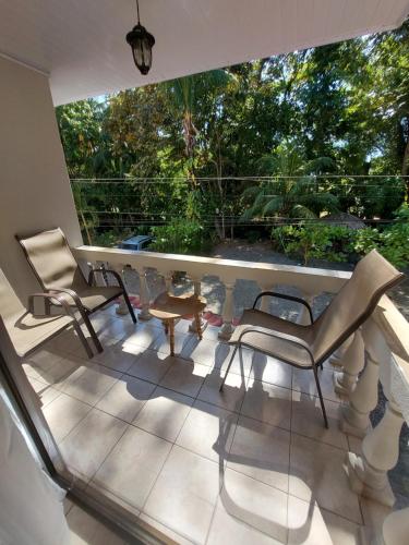 a balcony with two chairs and a table at Casa Arenas in Manuel Antonio