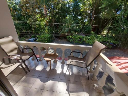 a balcony with chairs and a table and a window at Casa Arenas in Manuel Antonio