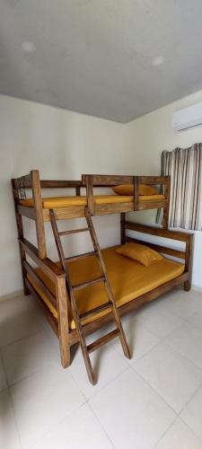 two bunk beds in a room with a ladder at Rancho Lyon Playa Costa Azul in Sonsonate