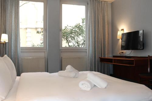 Hotel Mozart Bonn في بون: غرفة فندق عليها سرير وفوط