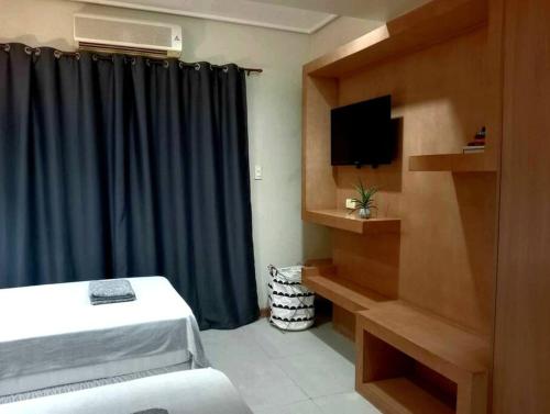 una habitación de hotel con cama y TV y una habitación en Z -Uno's Place, en Cebú