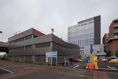 a building in the middle of a parking lot at Y's Hotel Asahikawa Ekimae in Asahikawa