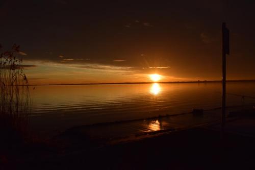 a sunset over a body of water with at Tom Schmid-Allone in Sármellék