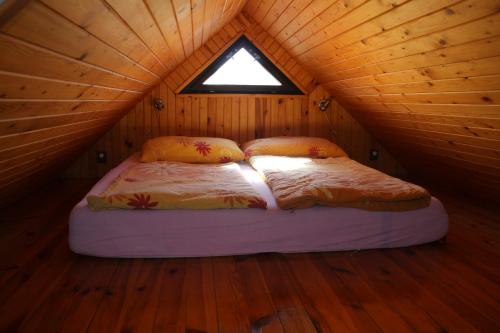 a bed in a wooden cabin with a window at Apartment Příbram in Příbram