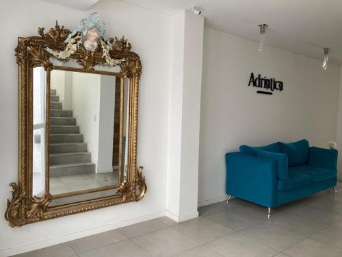 Habitación con espejo y sofá azul en Adriatica Apartamentos en San Luis