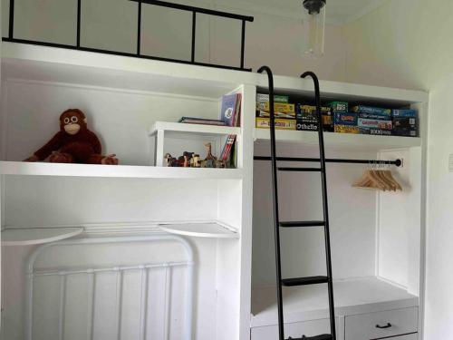 Litera blanca con escalera en una habitación en Comfy Queenslander Cottage, en Brisbane