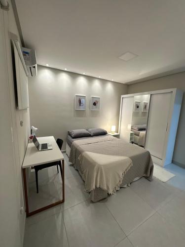 a bedroom with a large bed and a table at Apartamento completo em Caruaru - 2 quartos - Conforto e ótima localização para famílias in Caruaru