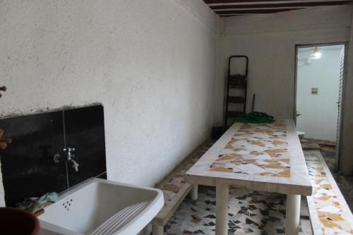 a room with a tub and a table and a counter at Casa de Alvenaria- Mauá in Mauá