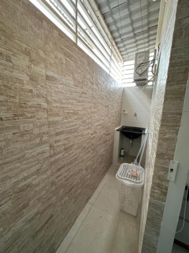 a bathroom with a brick wall and a toilet at Apt completo Caruaru, 2 quartos in Caruaru