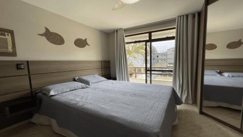 um quarto com 2 camas e uma janela em Lindo Apartamento em Canasvieiras Perto da Praia em Florianópolis