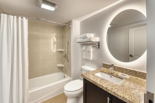 a bathroom with a sink and a toilet and a mirror at TownePlace Suites by Marriott Sudbury in Sudbury