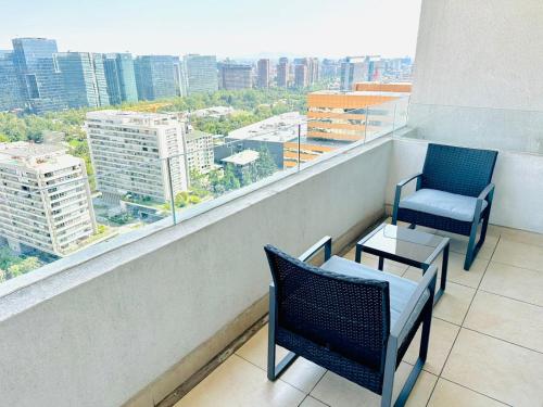 2 sillas y mesa en un balcón con vistas en Arauco Premium Suite, en Santiago