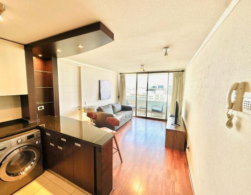a kitchen and living room with a washer and dryer at Arauco Premium Suite in Santiago