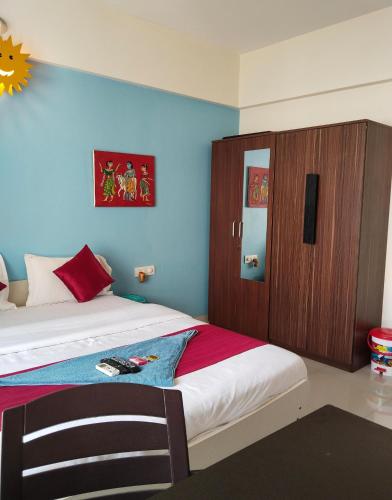 a bedroom with a bed and a wooden cabinet at GM Hospitality Services pune in Pune