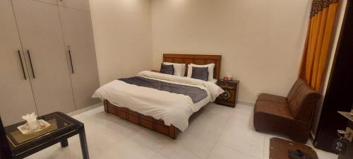 a small bedroom with a bed and a chair at RADIANT GUEST HOuSE 2 in Islamabad