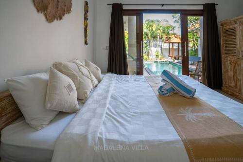 a bed with a suitcase sitting on top of it at Villa Madalena 4BR Family Villa w Pool Walk to best Beach & Cafe in Canggu