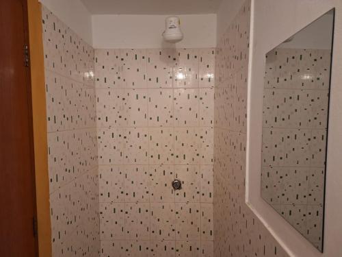 y baño con ducha y pared de azulejos. en Montañero Hostel II, en Huaraz