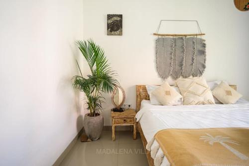 a bedroom with a bed and a potted plant at Villa Madalena 4BR Family Villa w Pool Walk to best Beach & Cafe in Canggu
