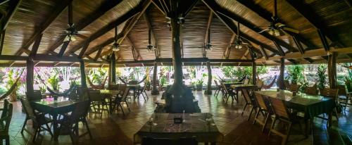 um restaurante com mesas e cadeiras num quarto em Lodge Barka Lounge em Jabilla