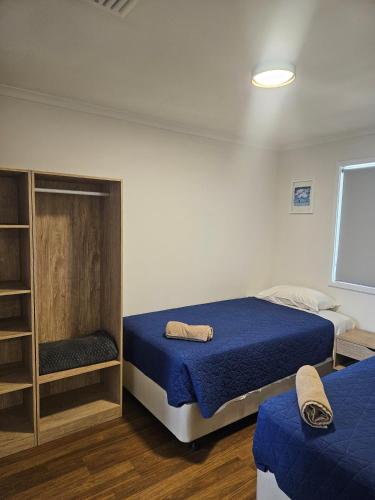 a bedroom with two beds and a book shelf at Central Caravan Park in Perth