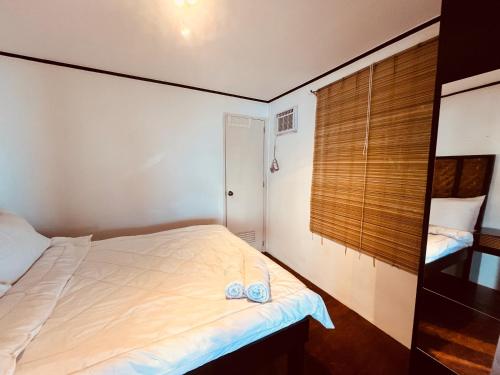 a small bedroom with a bed and a window at Villa Milagros Dive Inn Anilao in Mabini