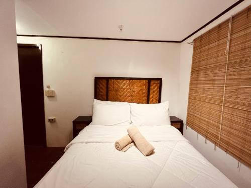 a bedroom with a bed with two towels on it at Villa Milagros Dive Inn Anilao in Mabini