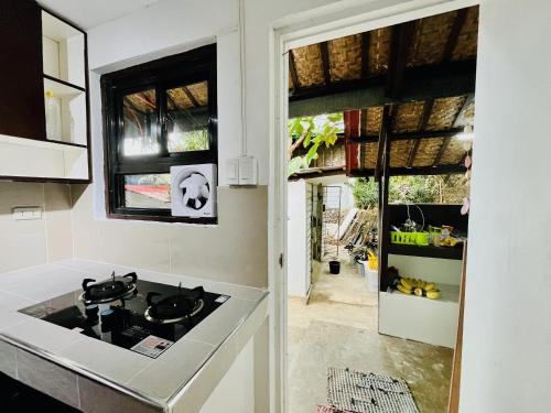 a kitchen with a stove top oven next to a door at Villa Milagros Dive Inn Anilao in Mabini