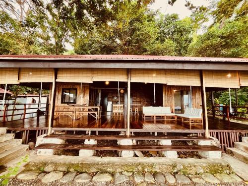 a house with a porch and stairs in front of it at Villa Milagros Dive Inn Anilao in Mabini