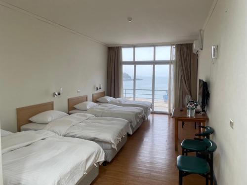 a row of beds in a room with a window at 馬港驛站 Oldharbor Hostel in Nangan