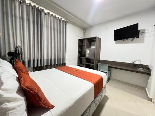 um quarto com uma cama e uma televisão de ecrã plano em HOTEL MAGIC em Piura