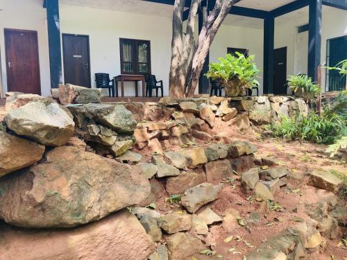 a stone retaining wall in front of a house at Nugasewana Guest in Anuradhapura