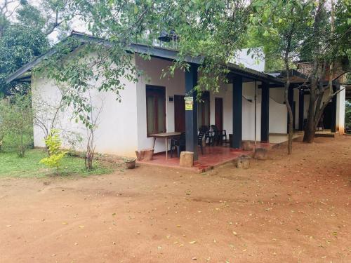 a white house with a dirt road in front of it at Nugasewana Guest in Anuradhapura