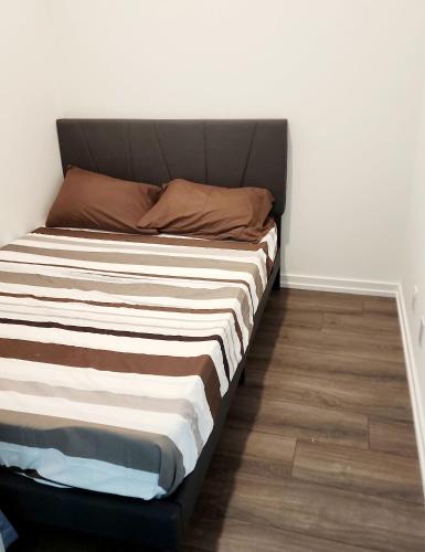 a bed in a room with a white wall at Aesthetic & classy apartment unit in Vaughan
