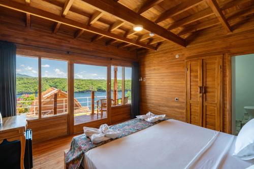 a bedroom with a large bed and a large window at Butterfly Villas Nusa Ceningan in Nusa Lembongan