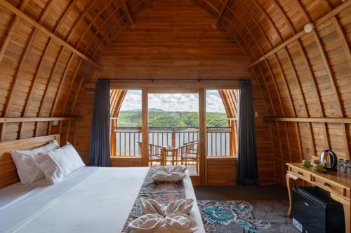 a bedroom with a bed and a large window at Butterfly Villas Nusa Ceningan in Nusa Lembongan