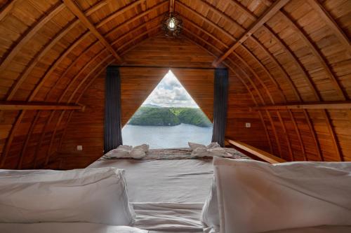 a large window in a wooden room with a bed at Butterfly Villas Nusa Ceningan in Nusa Lembongan
