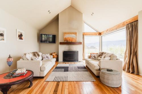 a living room with two couches and a fireplace at Chinamans Ridge on Chinamans Terrace - Bendigo, Tarras - Central Otago in Tarras