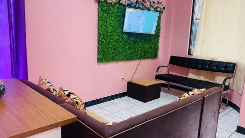 una sala de espera con un banco y una pared verde en Departamento vacacional en Puyo, en Puyo