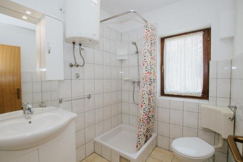 y baño con lavamanos y cortina de ducha. en Apartments Civadelić, en Trogir
