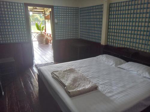 a bedroom with a bed in a room with a window at Friendship Guest House in Don Det