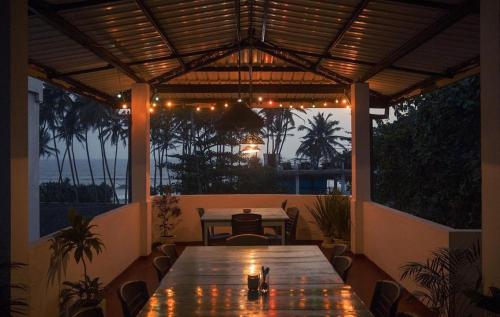 a wooden table on a patio with a view of the ocean at Neutral Wind Beach Home in Matara