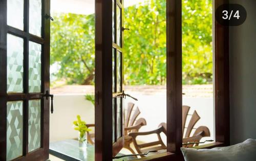 an open door to a patio with chairs outside at Neutral Wind Beach Home in Matara
